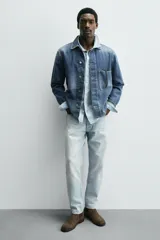 Bota estilo Chelsea de piel con acabado serraje color beige, con elásticos laterales para facilitar el calce, horma redonda y suela a tono con ligero tacón.