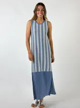 Vestido largo tejido a crochet, con rayas verticales color naranja y beige, sin mangas y con aberturas laterales.