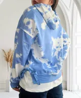 Buzo celeste con efecto tie-dye blanco, con capucha y cordones ajustables.