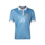 Camiseta oficial de la selección uruguaya de fútbol, color celeste con cuello polo blanco y detalles en azul. Presenta el escudo de la AUF en el pecho, número estampado y detalle conmemorativo en la parte inferior.