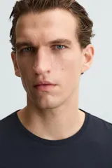 Camiseta slim fit de manga corta y cuello redondo, confeccionada en tejido de algodón con elasticidad.