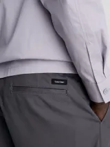 Shorts de corte slim color gris oscuro, confeccionados en sarga de algodón con elasticidad. Presentan talle medio, bragueta con cremallera, bolsillos laterales y de ojal en la parte trasera. Incluyen un cinturón con hebilla en forma de D.