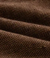 Blazer de corte regular confeccionado en tejido de poliéster con textura de espina de pez. Presenta cuello con solapa, cierre frontal de un botón, mangas largas y bolsillos laterales con solapa.