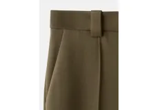 Pantalón de vestir verde militar, de corte recto y tiro alto, con bolsillos laterales y raya central marcada.