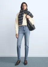Jeans tipo mom-fit de tiro alto con diseño de cinco bolsillos, trabillas y cierre frontal con cremallera y botón.
