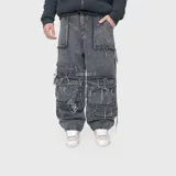 Pantalón jean ultra baggy de denim negro con efecto acid wash y roturas deshilachadas. Cuenta con múltiples bolsillos cargo y diseño holgado.