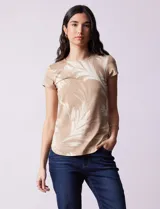 Remera color beige con estampado de hojas blancas, cuello redondo y mangas cortas.