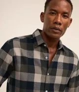 Camisa de algodón con estampado de cuadros en tonos azul, blanco y gris. Cuenta con cuello camisero, mangas largas abotonadas y corte comfort.