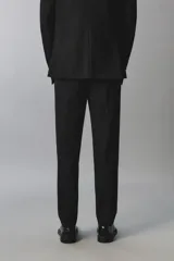 Pantalón de traje slim fit color negro, confeccionado en tejido con viscosa, con bolsillos frontales, bolsillos traseros de doble vivo y raya marcada en las piernas. Cuenta con cierre frontal con cremallera y botón.