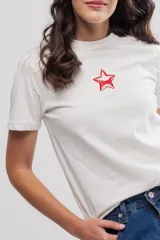 Remera blanca de algodón con estampado pequeño de una estrella roja en el pecho.
