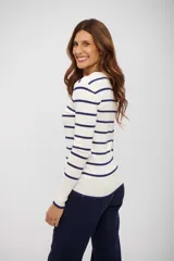 Buzo de tejido de punto color blanco con rayas horizontales azul marino. Presenta cuello redondo y mangas largas con puños y ruedo en azul marino.