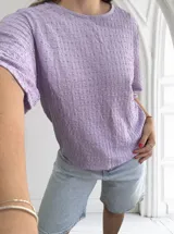 Blusa de manga corta color lila con cuello redondo y textura tejida en relieve con patrón de pequeños cuadros.