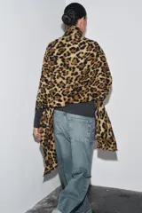 Pañuelo rectangular con estampado animal print de leopardo en tonos marrones y negros, con acabados deshilachados en los bordes.