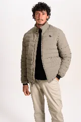 Campera puffer color beige con cierre frontal, cuello alto y logo de la marca bordado en el pecho.