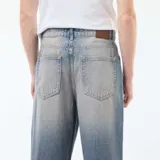 Pantalón jean celeste de corte ancho tipo baggy con 5 bolsillos.