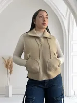 Chaleco beige con cierre frontal y bolsillos grandes.