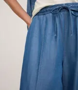 Pantalón femenino de corte wide leg, color azul, confeccionado en liocel. Presenta cintura elástica con lazo y detalle de nervura frontal.