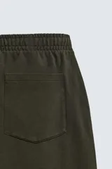 Pantalón jogger de algodón color verde oscuro, con efecto lavado, corte balloon fit y cintura elástica. Presenta bolsillos delanteros y bolsillos traseros de plastrón.