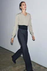 Jeans de tiro medio con corte flare y largo completo. Presenta bolsillos delanteros, cierre con cremallera, botón y ganchos metálicos.