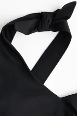 Malla enteriza de color negro con escote en V y breteles anchos con nudos decorativos en los hombros. Cuenta con copas con relleno extraíble y diseño completamente forrado.