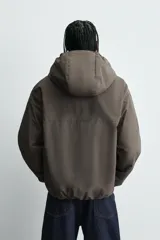 Cazadora relaxed fit de tejido técnico repelente al agua, con interior forrado en tejido polar. Presenta capucha ajustable, cierre frontal con cremallera, bolsillos con cierre en pecho y cadera, y puños y bajo con elástico.