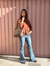 Cartera shopper de cuero color marrón chocolate, con doble asa de hombro, bolsillo frontal externo y diseño estructurado.