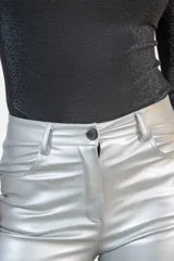 Pantalón de tiro medio confeccionado en eco cuero con acabado metalizado color plata, de corte recto y diseño clásico con bolsillos laterales y traseros.