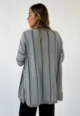 Saco de tejido de punto calado color marrón con detalles en color ladrillo.