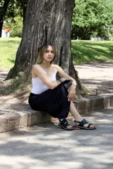 Sandalias bajas de cuero sintético color negro, con tiras cruzadas y hebilla lateral.