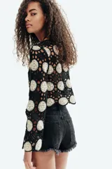 Short de denim negro de tiro superalto y corte clásico de cinco bolsillos, con detalles desgastados y bajos deshilachados.