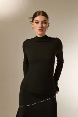 Polera de cuello alto y manga larga, confeccionada en tejido con textura arrugada y ajuste al cuerpo.