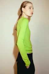 Jersey de punto fino confeccionado en lana, con cuello polo, cierre frontal de botones y manga larga.