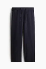 Pantalón de corte relajado confeccionado en una mezcla de lino y viscosa. Presenta cintura elástica con cordón de ajuste, bolsillos laterales al bies y un bolsillo trasero insertado.