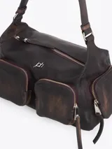 Cartera de hombro confeccionada en cuero vacuno color bordó con acabado desgastado. Presenta múltiples bolsillos exteriores con cierre en el frente, dorso y laterales, herrajes metálicos plateados y logo de la marca aplicado en el frente.