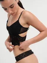 Corset blanco de encaje con copas con aros y breteles finos regulables.