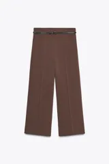 Pantalón culotte marrón de tiro medio con cintura con trabillas y cinturón fino efecto piel negro con hebilla metálica. Presenta raya planchada y cierre con cremallera oculta en la costura.