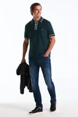 Polo de manga corta en tejido mesh color verde oscuro, con cuello y tapeta de botones en contraste con ribete blanco. Presenta el logo del pingüino bordado en el pecho.