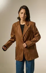 Blazer de gamuza color marrón, con cuello solapa, cierre frontal con un botón, bolsillos frontales tipo parche y diseño holgado.