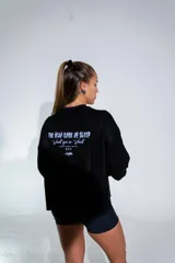 Buzo de tejido de punto fino en color negro, con diseño de cuello redondo y corte holgado. Presenta un estampado gráfico estilo gótico en el centro del pecho.