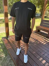 Remera oversize negra de manga corta, con gran estampado tipográfico blanco en la espalda con la inscripción "TOP STYLE Collections" y detalles gráficos.