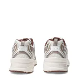 Championes New Balance 530, calzado de estilo retro running en tonos beige, marrón y blanco, con detalles metalizados, capellada de malla transpirable con superposiciones sintéticas, y suela con tecnología ABZORB.