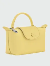 Cartera pouch tipo clutch de mano, marca Longchamp, modelo Le Pliage One. Diseño en color amarillo con solapa de cuero texturizado y botón a presión grabado, asa superior corta y cierre de cremallera con tirador metálico circular.