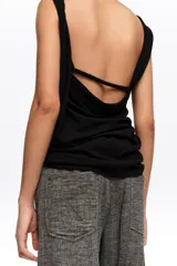 Pantalón tobillero de corte barrel color gris, confeccionado en mezcla de algodón y lino. Presenta cierre frontal con corchete oculto y cremallera, tiro medio, bolsillos delanteros en costura y bolsillos tipo plastrón en la parte trasera.
