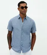 Camisa de manga corta confeccionada en mezcla de lino y algodón, con cuello inglés, cierre frontal de botones y bolsillo en el pecho. Presenta un corte comfort holgado y diseño liso.
