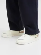 Championes urbanos Jack & Jones modelo Wealing, de diseño clásico con puntera redonda y cordones. Presentan una capellada en color blanco hueso con detalles en tono marrón y beige en el talón y laterales. Cuentan con suela de goma resistente.