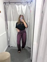 Jean color uva, de corte relajado, tiro alto y diseño de perneras ligeramente curvas con costuras decorativas frontales.