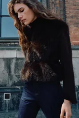 Chaqueta de punto gris con frente de piel sintética, cuello redondo, manga larga y cinturón fino efecto piel incorporado en la cintura. Cuenta con cierre frontal mediante ganchos metálicos y forro interior.