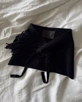 Culerito de descarne vacuno color negro, con diseño envolvente y flecos laterales. Cuenta con tiras para atar en la cintura y etiqueta de la marca Lucy in the Sky.