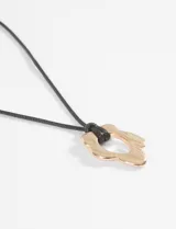 Collar de cordón negro con dije metálico en forma de flor irregular de acabado plateado. Incluye cadena de alargue metálica con cierre de mosquetón.