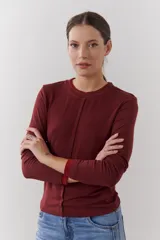 Remera color beige de mangas largas con cuello redondo y puños blancos en contraste.